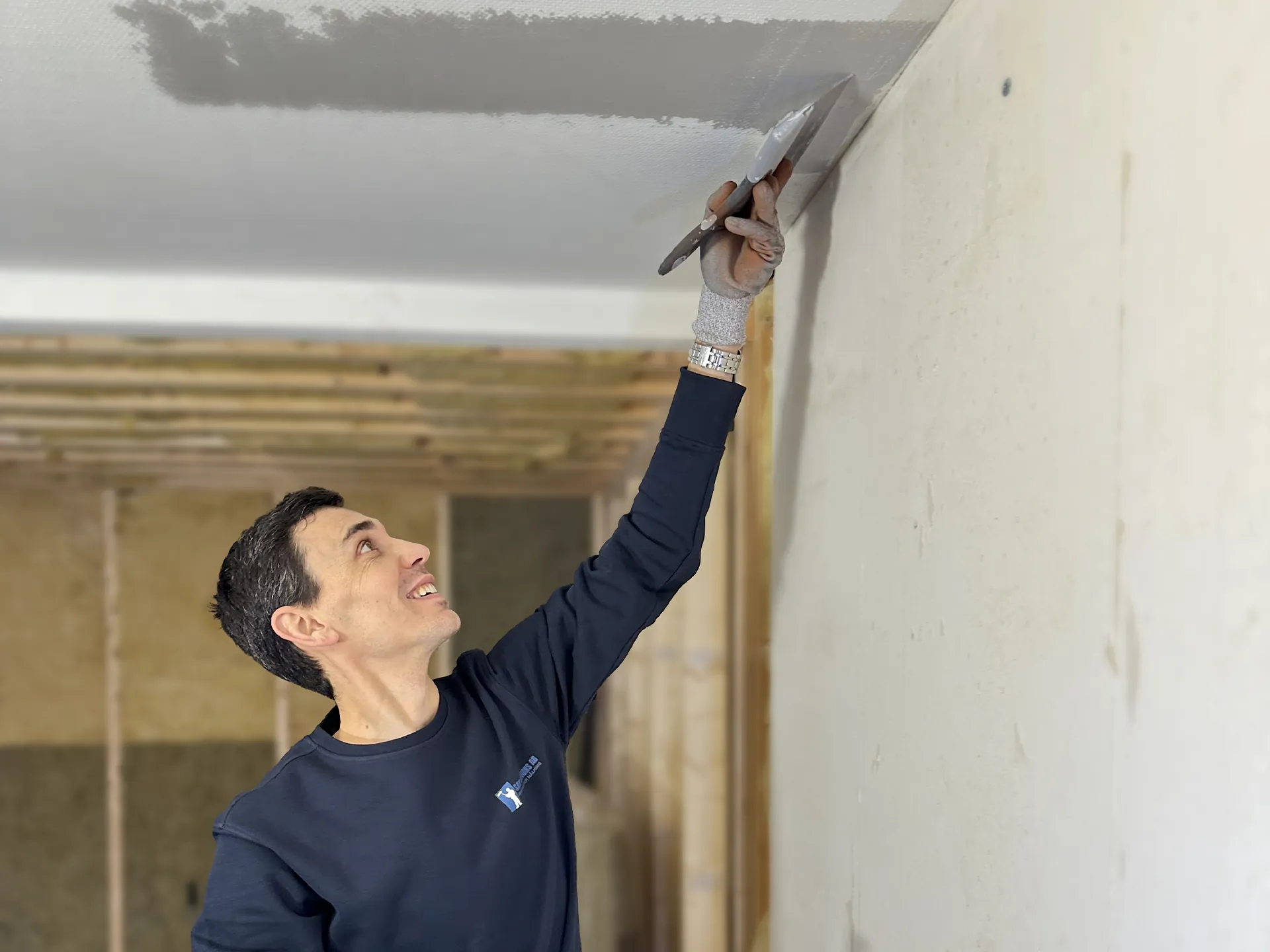 Hantverkare från SAVL Solutions utför noggrann bredspackling av tak för en slät och modern yta.