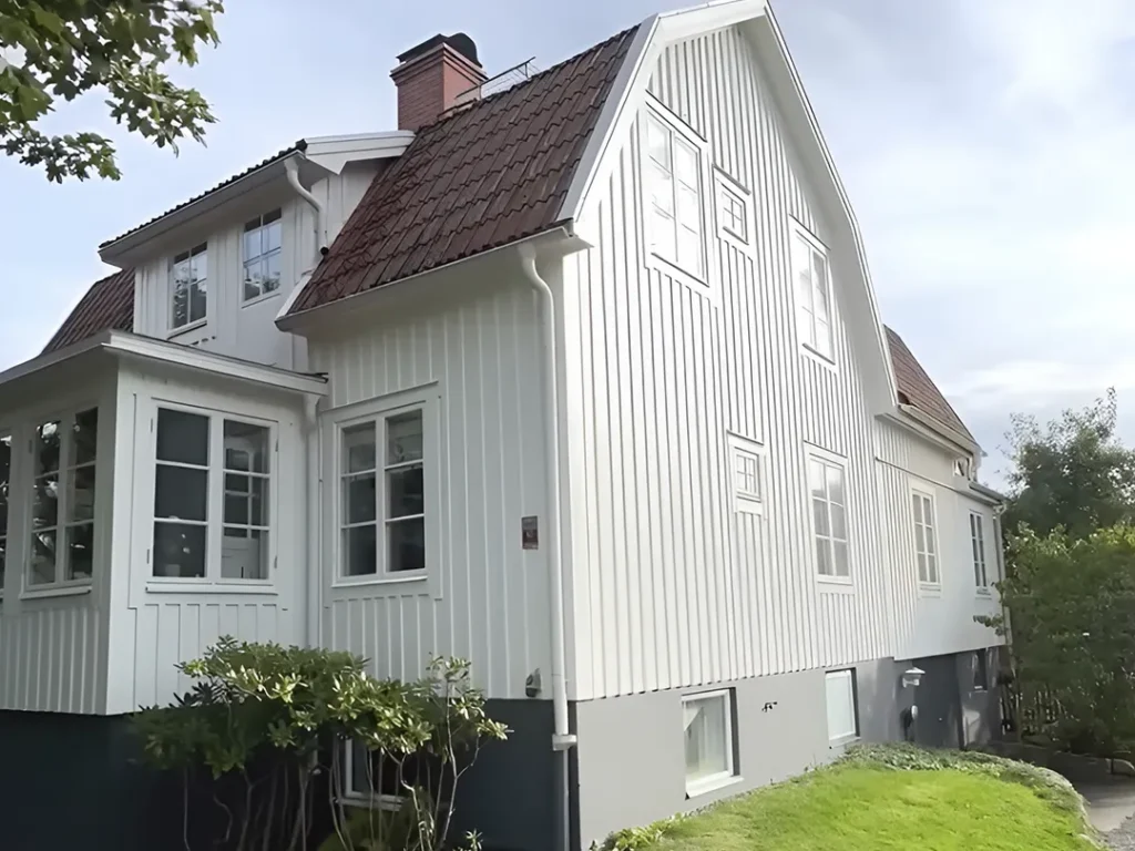 Färdigmålad vit träfasad på trähus i Karlstad