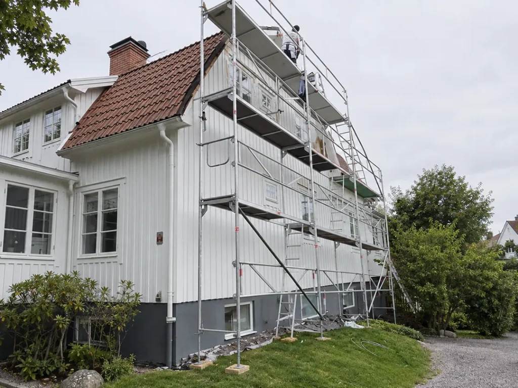 Fasadmålning av trähus i Karlstad med byggställning inför målning