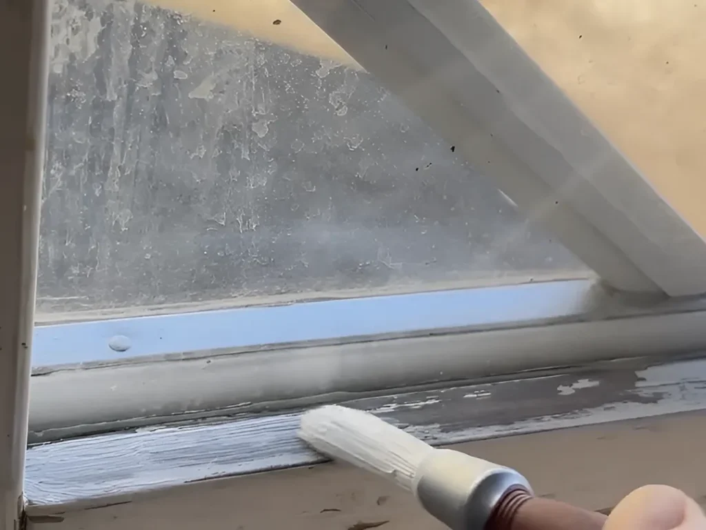 Målning av slitet träfönster under fönsterrenovering i Karlstad för ett hållbart och snyggt resultat.
