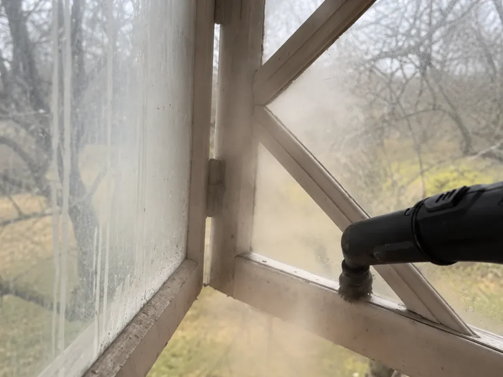 Rengöring av gammalt träfönster inför fönsterrenovering och målning i Karlstad.