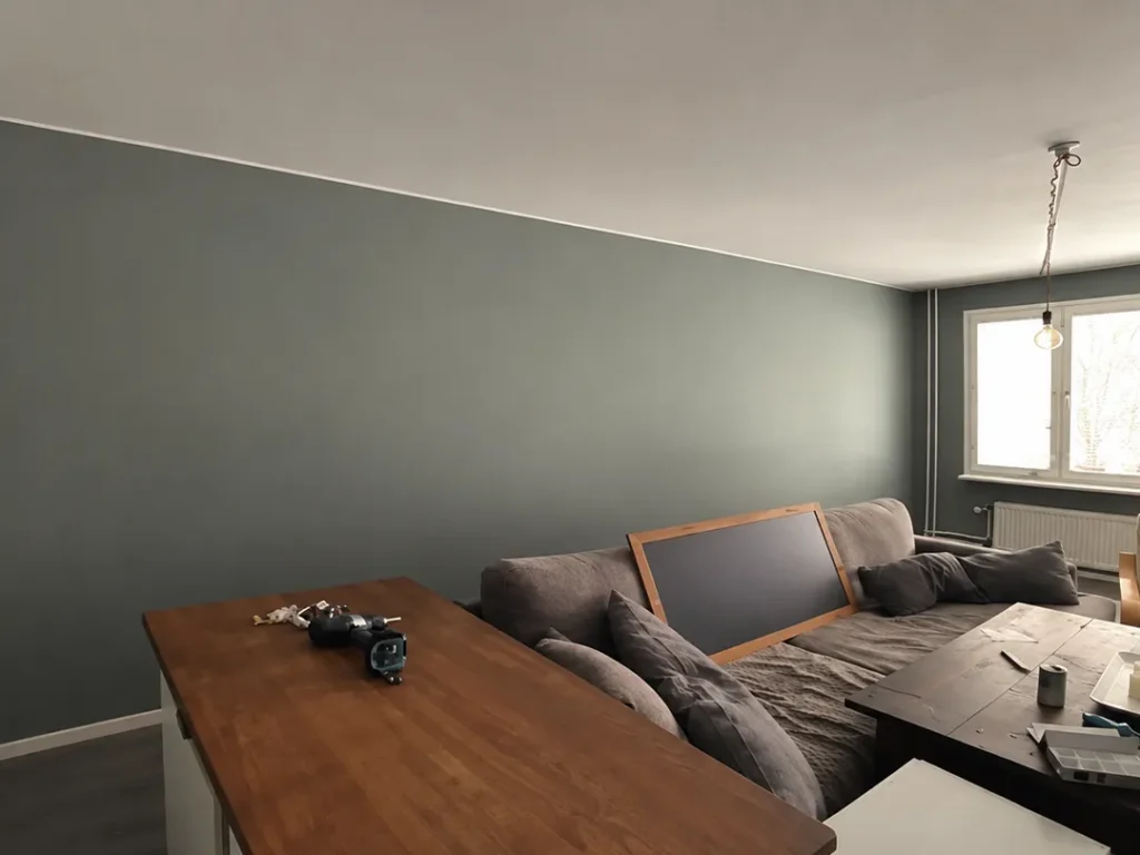 Färdigt vardagsrum med grågröna väggar efter invändig målning i Karlstad