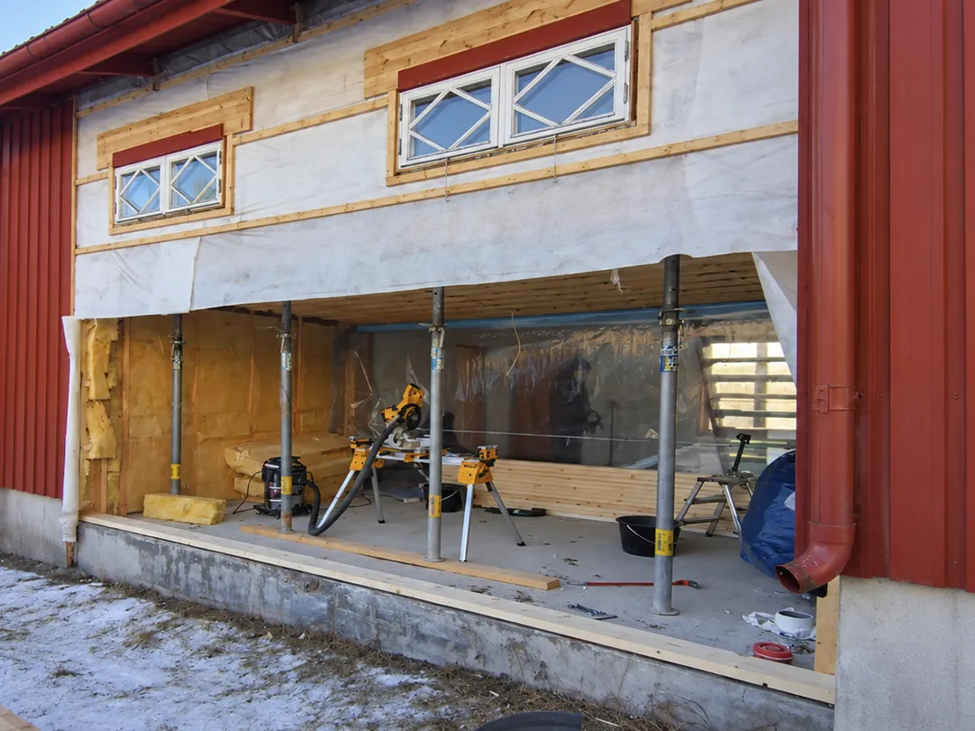Hus i Karlstad under totalrenovering med öppnad fasad och pågående byggarbete.